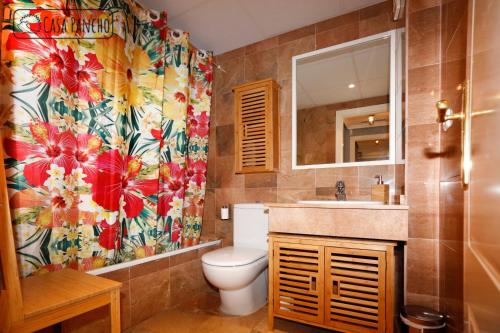 ein Bad mit einem WC und einem Blumenduschvorhang in der Unterkunft Apartamento Milla de oro 5 Personas in Marbella
