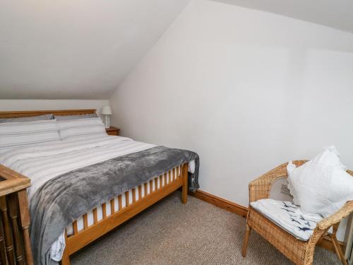 a bedroom with a large bed and a chair at The Coach House in Bristol