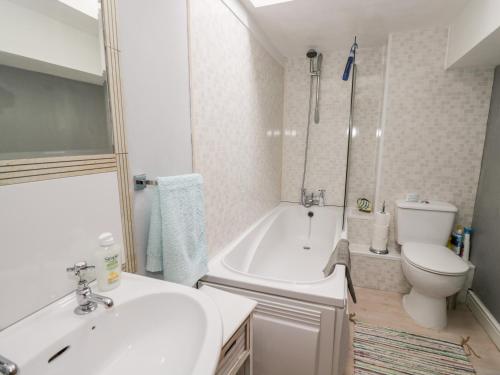 a bathroom with a tub and a toilet and a sink at The Coach House in Bristol