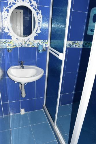 a blue bathroom with a sink and a mirror at Posada Sweet Anashly in Providencia