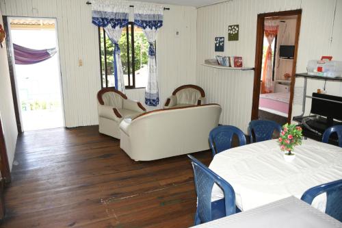 a living room with two tables and two white chairs at Posada Sweet Anashly in Providencia