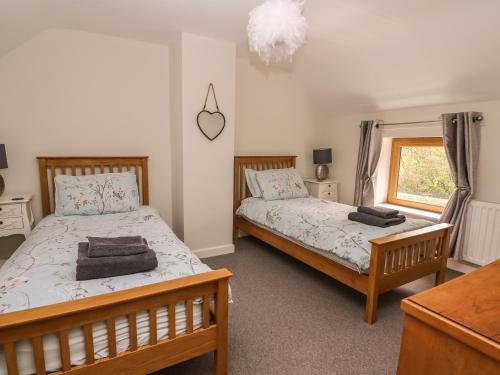 a bedroom with two beds and a window at The Farmhouse in Capel Bangor