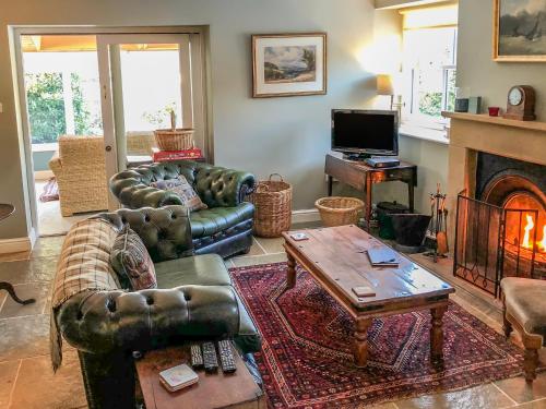 a living room with leather furniture and a fireplace at The Granary in Appleton le Moors