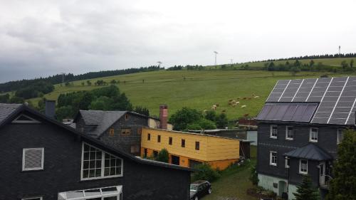 a group of houses with solar panels on a hill at Gasthaus & Pension Am Rennsteig in Spechtsbrunn
