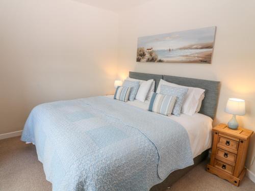 a bedroom with a bed with a blue comforter at The Byre in Ashbourne