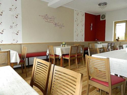 a dining room with tables and chairs in a restaurant at Gasthaus & Pension Am Rennsteig in Spechtsbrunn
