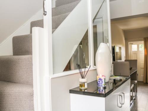 a living room with a glass table with a mirror at Ash Cottage in Bakewell