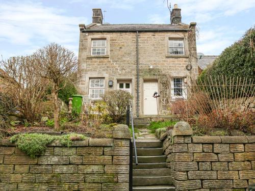 an old brick house with a stone wall at Ash Cottage in Bakewell