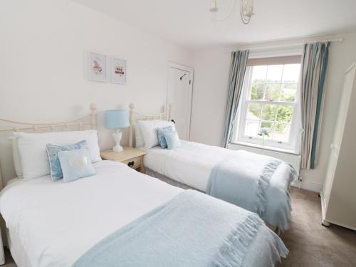 two beds in a white room with a window at Croft View in Whitby