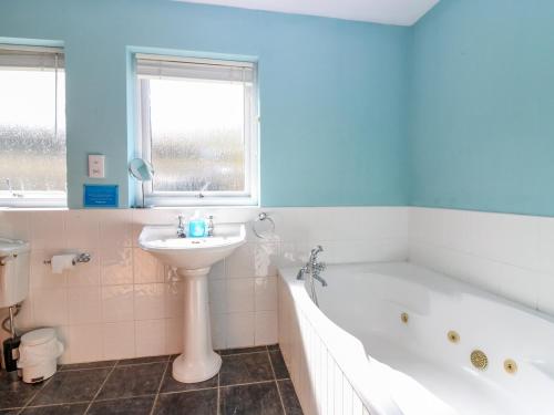a bathroom with a tub and a sink and a bath tub at Starfish Cottage in Craignure