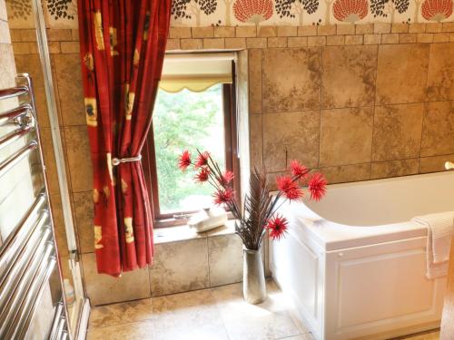 a bathroom with a vase with flowers in it at Woodlands in Halton West
