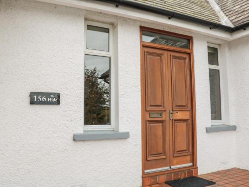 a house with a wooden door on the side of it at The Hide, Newtownards in Greyabbey