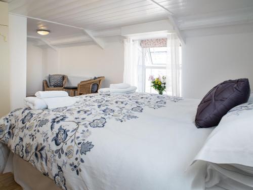 a bedroom with a large bed with a blue and white comforter at 3 Horse Pool Road in Laugharne