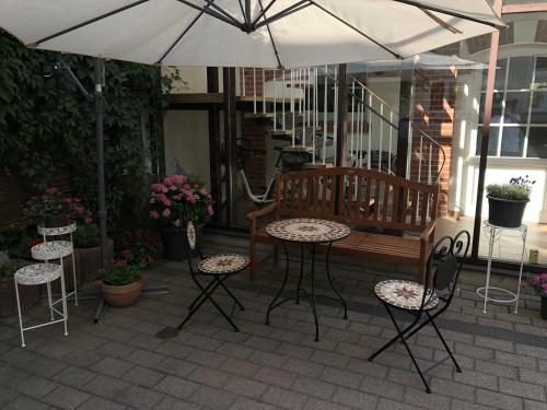 une terrasse avec une table, des chaises et un parasol dans l'établissement Central-Hotel Torgau, à Torgau