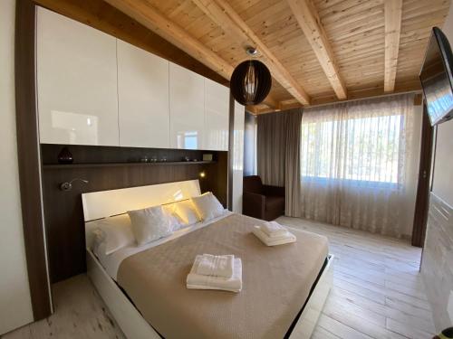 una camera da letto con un grande letto con due asciugamani di VILLA SICILIA a Calatabiano
