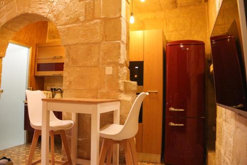 a kitchen with a table and chairs and a refrigerator at Malta's Naughtiest Cabaret in Il-Furjana