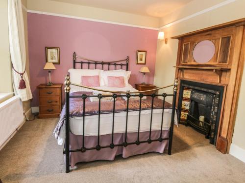 1 dormitorio con 1 cama y chimenea en Rowan Cottage, en Grasmere