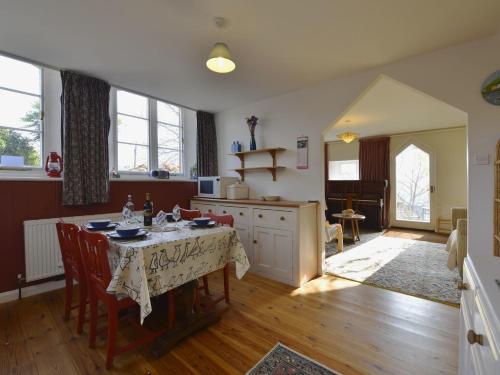 a kitchen with a table with chairs and a dining room at The Old School House in Lustleigh