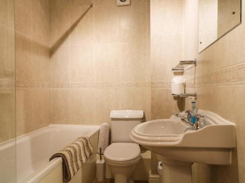 La salle de bains est pourvue de toilettes, d'un lavabo et d'une baignoire. dans l'établissement Siskin, à Keswick