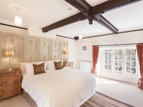 a bedroom with a large white bed and a window at Great Bidlake Manor in Bridestowe
