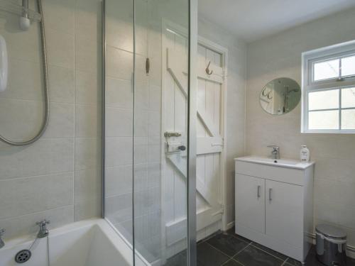 Little Week Cottage في Bridestowe: حمام مع دش وحوض استحمام ومغسلة
