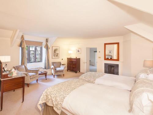 a bedroom with a large bed and a fireplace at Great Bidlake Manor in Bridestowe