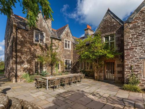an old brick building with a picnic table in the courtyard at Great Bidlake Manor in Bridestowe