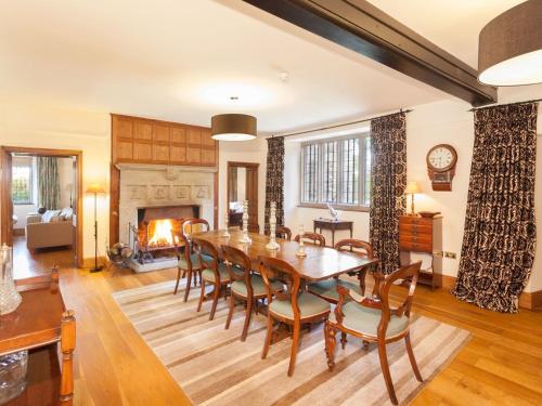 a dining room with a table and chairs and a fireplace at Great Bidlake Manor in Bridestowe