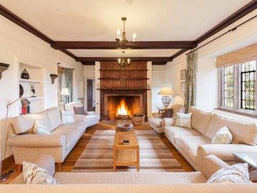 a living room with couches and a fireplace at Great Bidlake Manor in Bridestowe