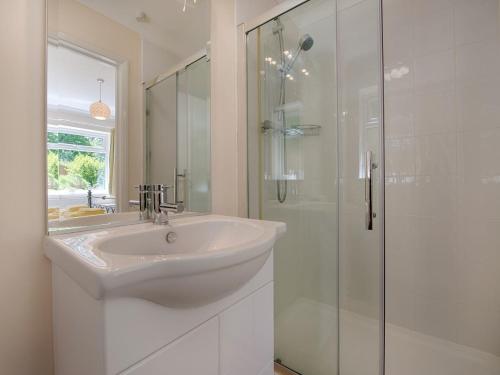 a white bathroom with a sink and a shower at Exe View in Dawlish
