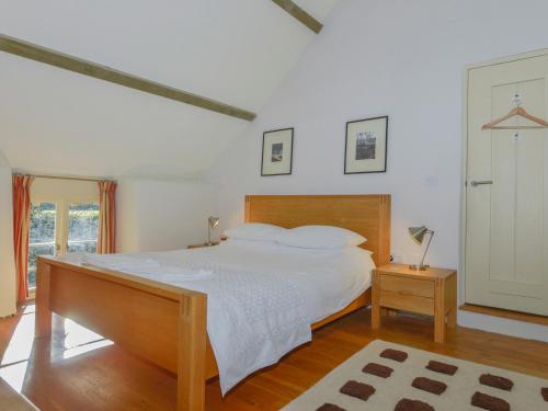 a bedroom with a large white bed and a window at The Bakehouse in Gidleigh