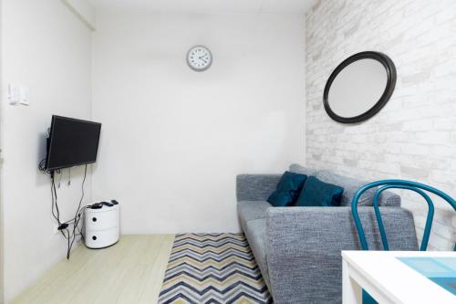 a living room with a gray couch and a mirror at 1BR Interiored Condo with WiFi, Netflix, Hot Shower - The Hive Residences in Taytay
