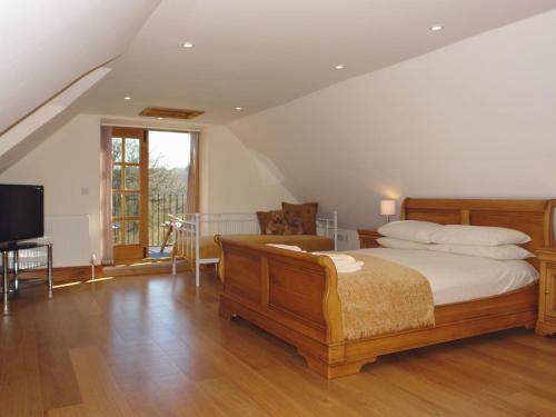 een slaapkamer met een bed en een televisie. bij Hiscox Cottage in Southleigh