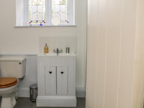 a bathroom with a sink and a toilet at Alice Cottage in Minehead