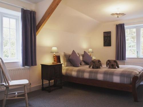 a bedroom with a bed with two stuffed animals on it at Heyden Cottage in Minehead