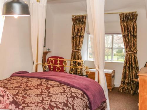 a bedroom with a canopy bed with curtains at 11 The Green in Budleigh Salterton
