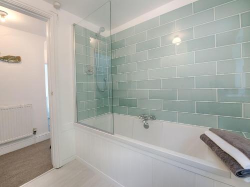 W łazience znajduje się wanna i przeszklony prysznic. w obiekcie 1 The Quay w mieście Lympstone