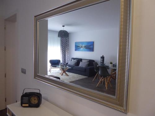 een gouden spiegel in een woonkamer met een bank bij NORASUITES32 in La Laguna