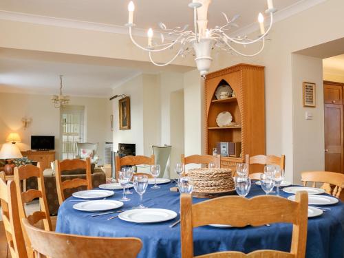 a dining room with a blue table and chairs at Sandridge Barton in Stoke Gabriel