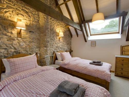 En eller flere senge i et værelse på Whitcombe Cottage
