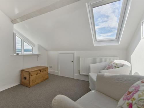 a white living room with a white couch and two windows at 1 The Quay in Lympstone