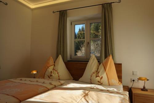 1 dormitorio con cama con almohadas y ventana en Jagerdichtlgut, en Altaussee