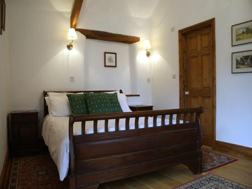 1 dormitorio con 1 cama y puerta de madera en East Bickleigh en Totnes