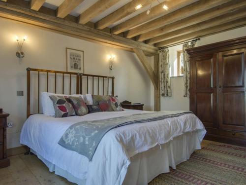 Un dormitorio con una cama grande en una habitación con techos de madera. en The Roundhouse en Halwell
