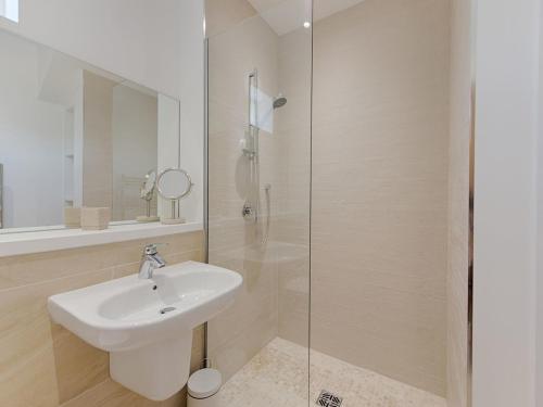 a bathroom with a sink and a glass shower at 5 Beachdown in Bigbury