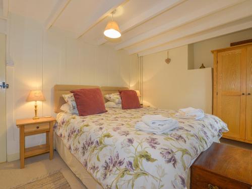 a bedroom with a bed with towels on it at 1 Gabberwell Cottages in Kingston