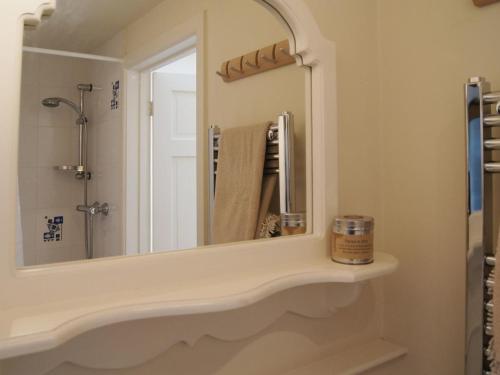 uma casa de banho com um lavatório e um espelho em Cherry Tree Cottage em Noss Mayo
