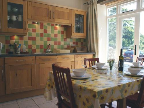 una cocina con mesa y mantel. en The Clock House en Harford