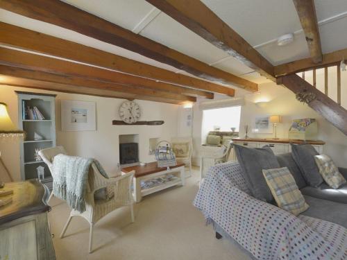 een woonkamer met een bank en een open haard bij Mays Cottage in Saint Issey