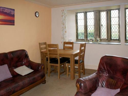 ein Wohnzimmer mit einem Holztisch und Stühlen in der Unterkunft Tresungers Cottage in Port Isaac